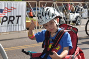 Thumbs up by an a young adapted cyclist who is having fun.